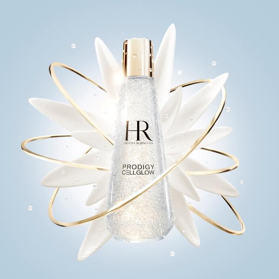 A sparkling glass bottle of Prodigy Cellglow skincare serum, surrounded by elegant petals and a golden swirl on a light blue background.