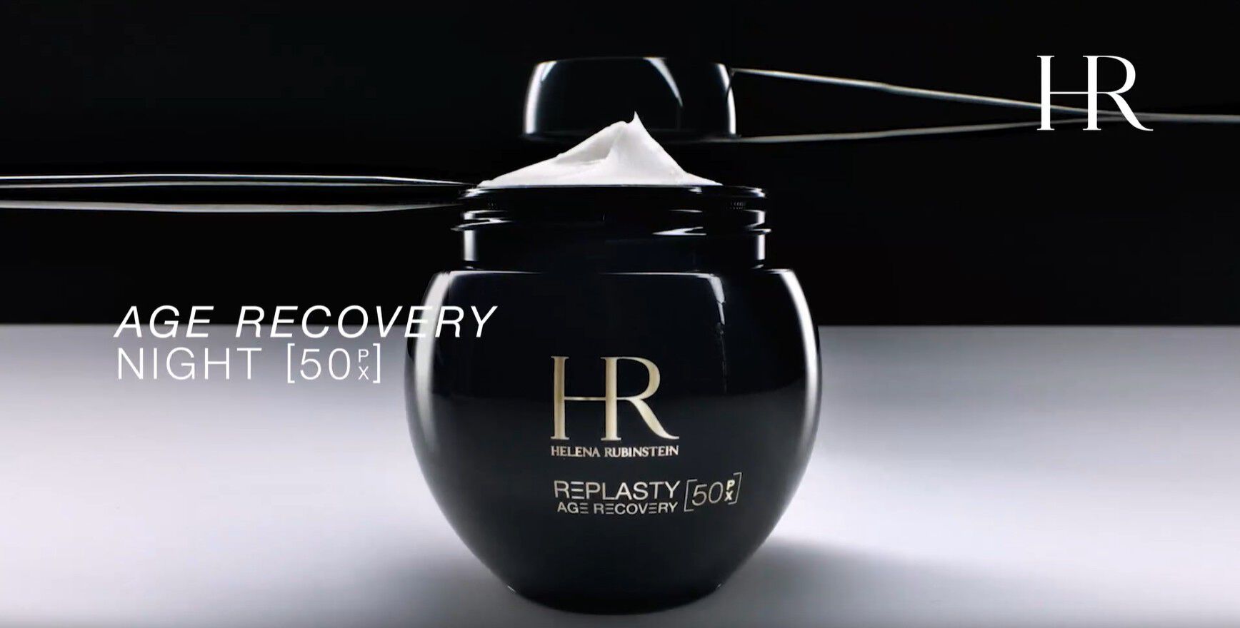 Video van de nieuwe navulbare Helena Rubinstein Re-Plasty Age Recovery [50PX] pot, geopend met zichtbare creme erin, weergegeven tegen een donkere achtergrond.​