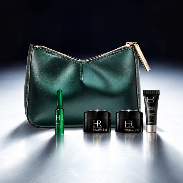 Een groene cosmetische etui van Helena Rubinstein voor een helder landschap, omringd door vier miniatuur huidverzorgingsproducten.