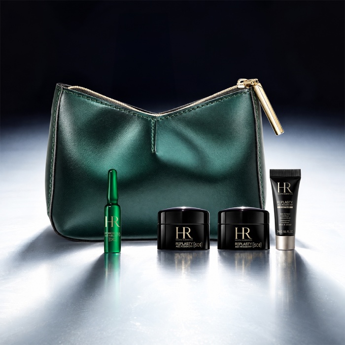 Een groene cosmetische etui van Helena Rubinstein voor een helder landschap, omringd door vier miniatuur huidverzorgingsproducten: een Re-Plasty crème, een Powercell [EXO] mini-serum, een Powercell Skinmunity serum en een Pure Ritual cleanser.​